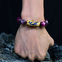 Purple sea willow bracelet worn on wrist against dark rocky background