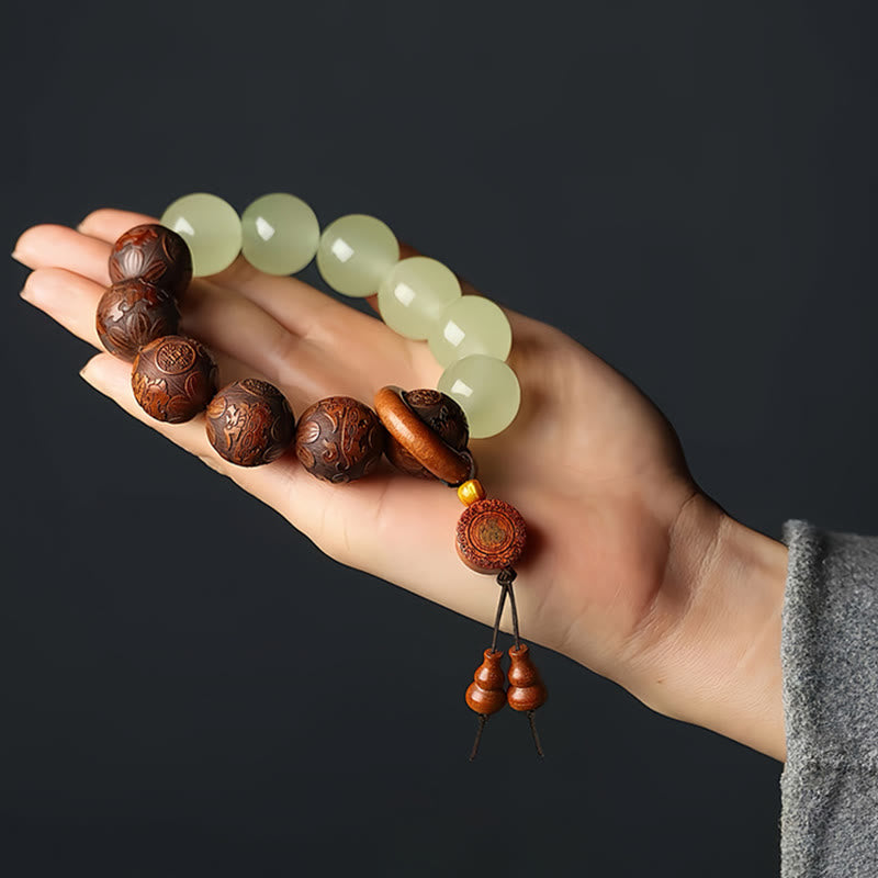 Sappan Wood Engraved Pixiu Fu Bracelet – palm display on dark background with gourd pendants, healing spiritual jewelry