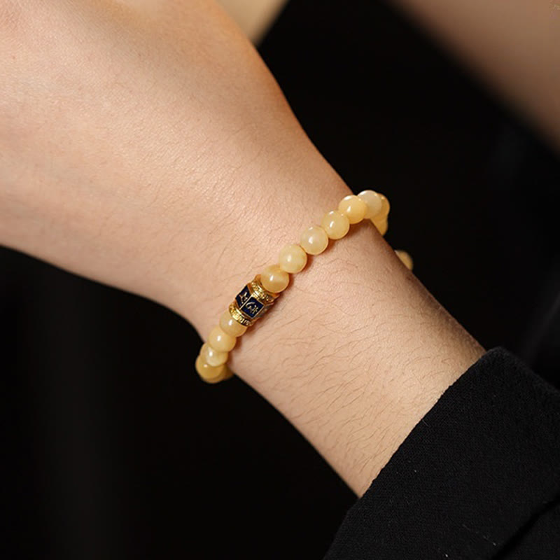 Om Mani Padme Hum Bracelet – Worn on wrist against black clothing showing warm topaz tones, bead jewelry