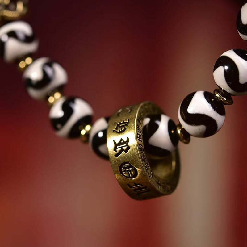 Tibetan Dzi Bead & Copper Om Mani Padme Hum Bracelet – Macro detail of engraved Om Mani Padme Hum brass ring on patterned beads, mantra bracelet