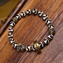 Tibetan Dzi Bead & Copper Om Mani Padme Hum Bracelet – Three-quarter view showing black-white patterned beads and gold spacers, tibetan bracelet