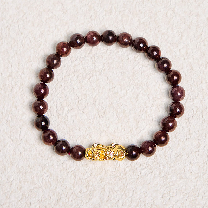 Natural Garnet Pixiu Protection Bracelet – full circle view on textured white background, dark red garnet beads with gold Pixiu charm, wealth luck