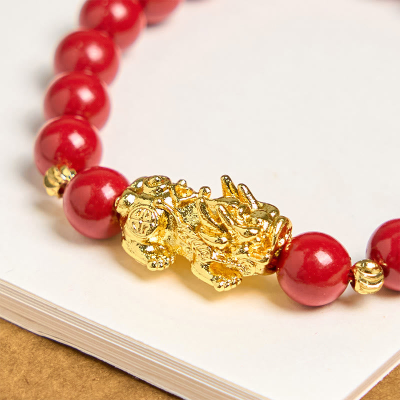 Cinnabar Pixiu Calm Bracelet – close-up of ornate gold Pixiu charm between glossy red cinnabar beads, feng shui wealth protection detail