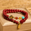 Cinnabar Pixiu Fu Bracelet – front view on gold box showing double wrap red cinnabar beads with enamel flower and Pixiu charm, feng shui