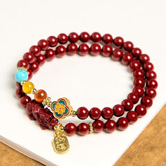 Cinnabar Pixiu Fu Bracelet – flat lay on white surface showing full double wrap design with red cinnabar beads, Pixiu and Fu tag, blessing
