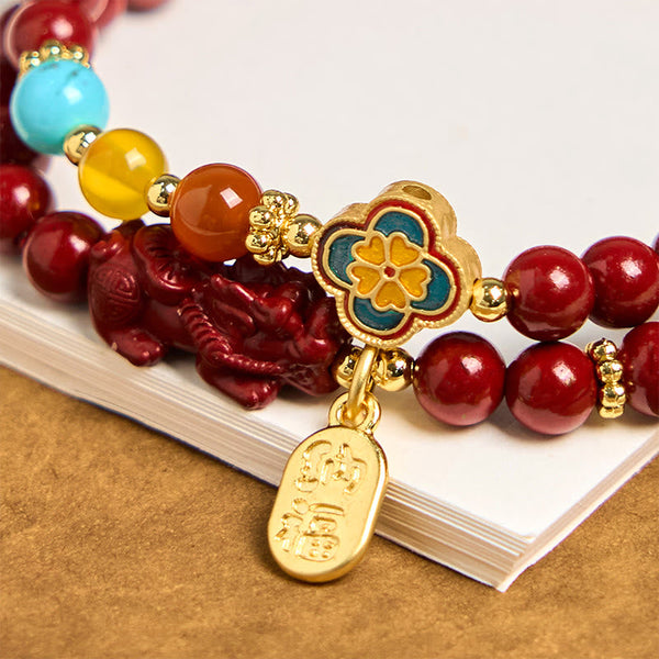 Cinnabar Pixiu Fu Bracelet – close-up of enamel flower, gold Fu tag, red Pixiu and turquoise amber beads, good fortune feng shui