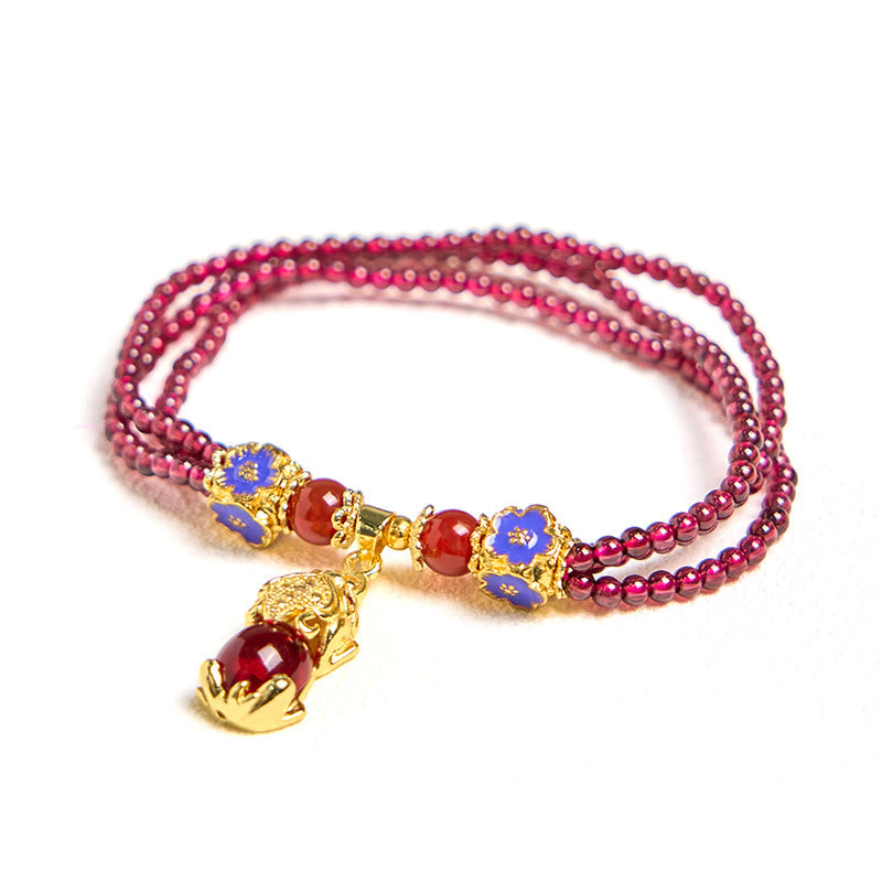 Garnet Pixiu Flower Bracelet – clean product shot on white background showing triple strand garnet beads with blue flowers and gold Pixiu, luck