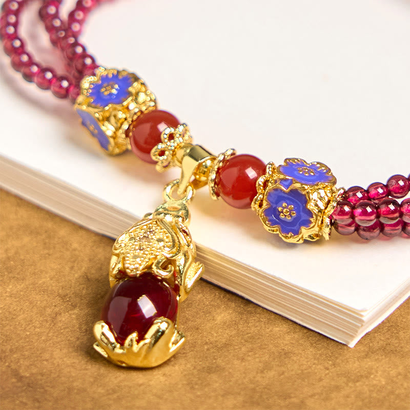 Garnet Pixiu Flower Bracelet – close-up of gold Pixiu pendant with red stone, blue enamel flower charms and red agate beads, feng shui wealth