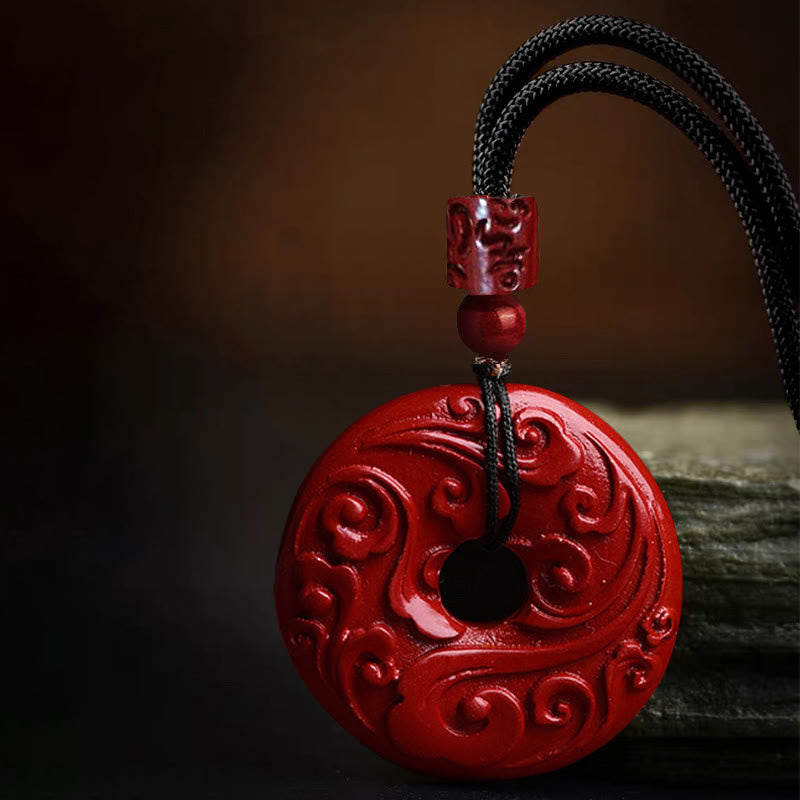 Cinnabar Lotus Peace Buckle Necklace - three-quarter view of carved red pendant on dark surface, Dramatic
