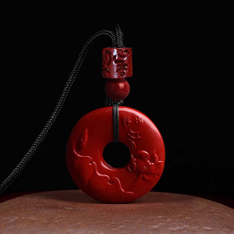Cinnabar Lotus Peace Buckle Necklace - front view of lotus carved bi-disc on black backdrop, Striking