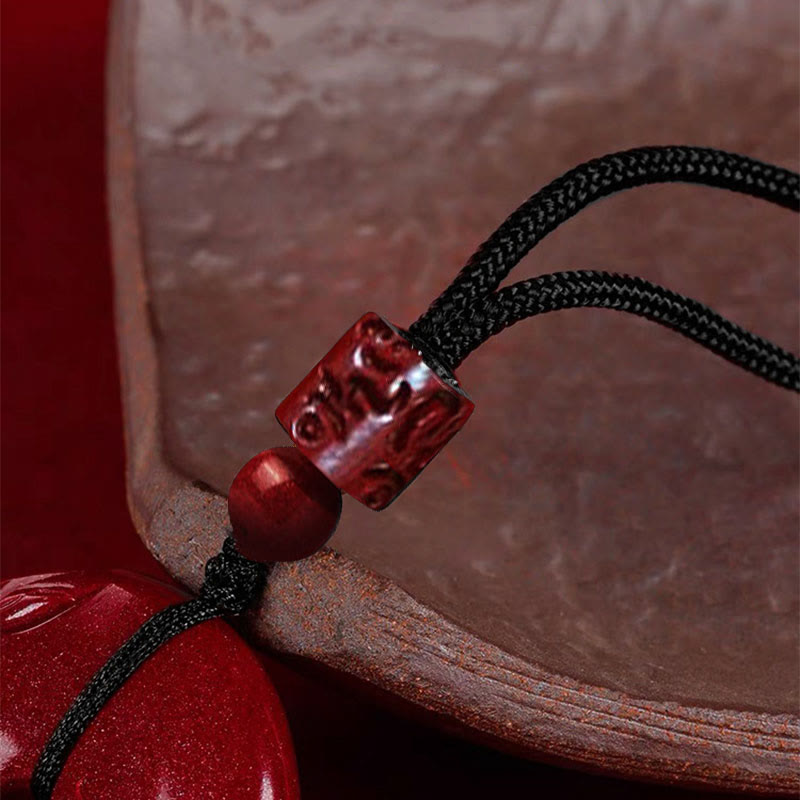 Cinnabar Lotus Peace Buckle Necklace - macro detail of carved cube bead and cord knot, Detailed