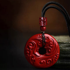 Cinnabar Lotus Peace Buckle Necklace - three-quarter view of carved red pendant on dark surface, Dramatic