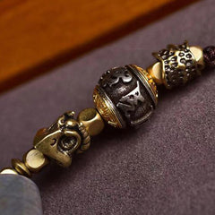 Tibetan Dzi Bead Agate Protection Pendant – close-up detail, inscribed metal beads and skull charm, ethnic beaded jewelry