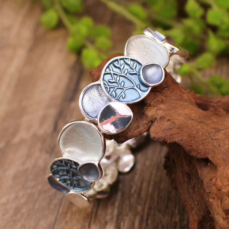 Tree of Life Alloy Elastic Bracelet – blue-toned discs on driftwood with foliage, low three-quarter angle