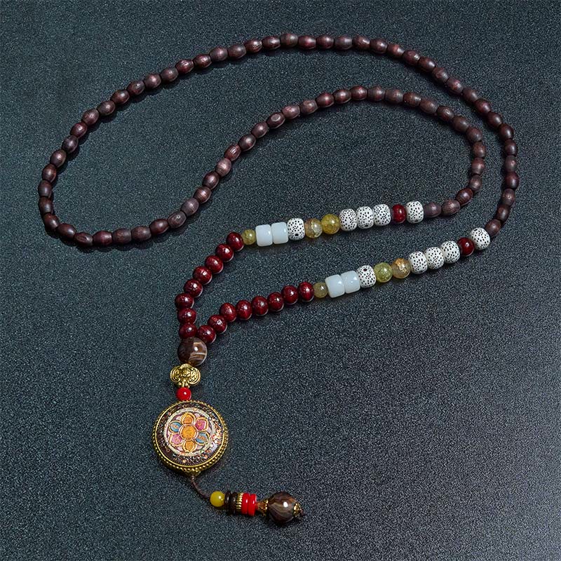 Tibetan Om Mani Padme Hum Necklace – S-curve flat lay showing mixed beads, vajra mandala pendant, dark bg
