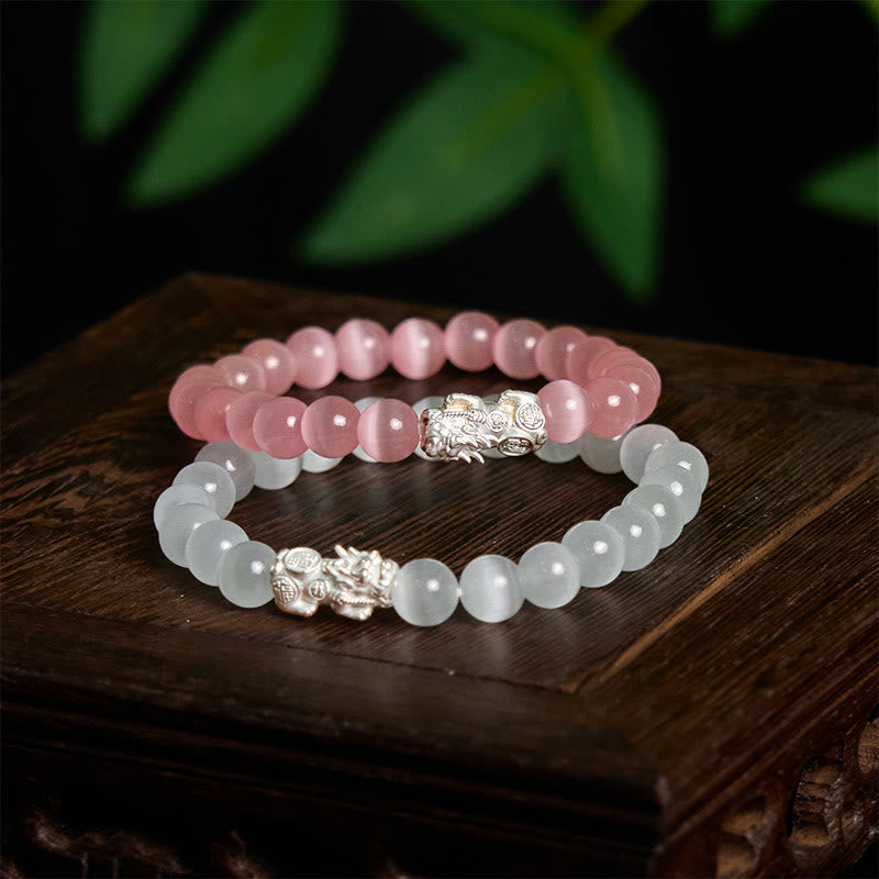 Cat's Eye 990 Sterling Silver Pixiu Positive Energy Bracelet – pink and white cat's eye bracelets stacked together on rustic wood, wealth luck pair