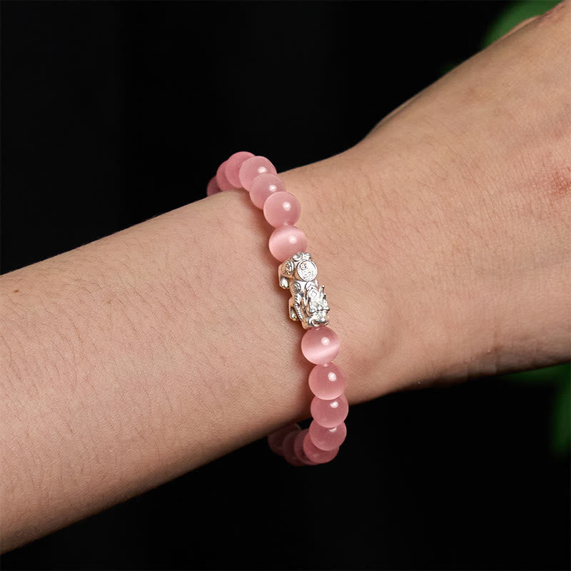 Cat's Eye 990 Sterling Silver Pixiu Positive Energy Bracelet – pink cat's eye bracelet worn on wrist with detailed silver Pixiu, feminine energy