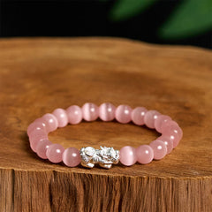 Cat's Eye 990 Sterling Silver Pixiu Positive Energy Bracelet – pink cat's eye beads with silver Pixiu charm on wooden stump, love energy bracelet