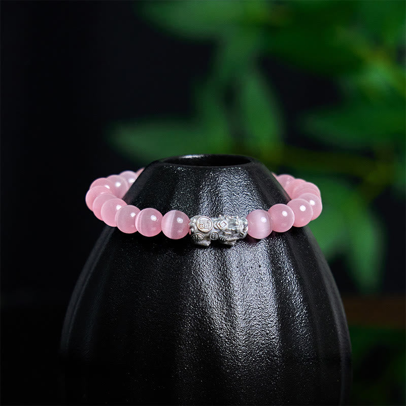 Cat's Eye 990 Sterling Silver Pixiu Positive Energy Bracelet – angled view pink bracelet on black vase showing Pixiu craftsmanship, luck talisman