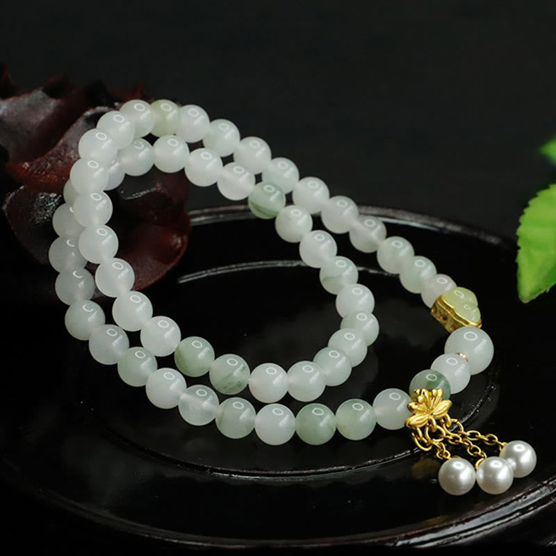 Tianshan Jade Lotus Gourd Bracelet – Full coiled view on black dish with jade translucency, lotus jewelry