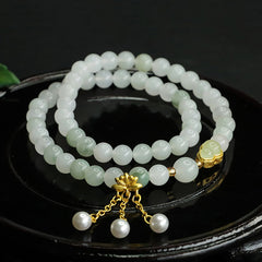 Tianshan Jade Lotus Gourd Bracelet – Coiled on black dish with gold lotus charm and pearl tassels, jade bracelet