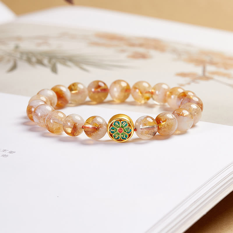 Sterling Silver Citrine Bracelet – three-quarter view on open book, golden citrine beads with green enamel lotus charm, cr... Main image