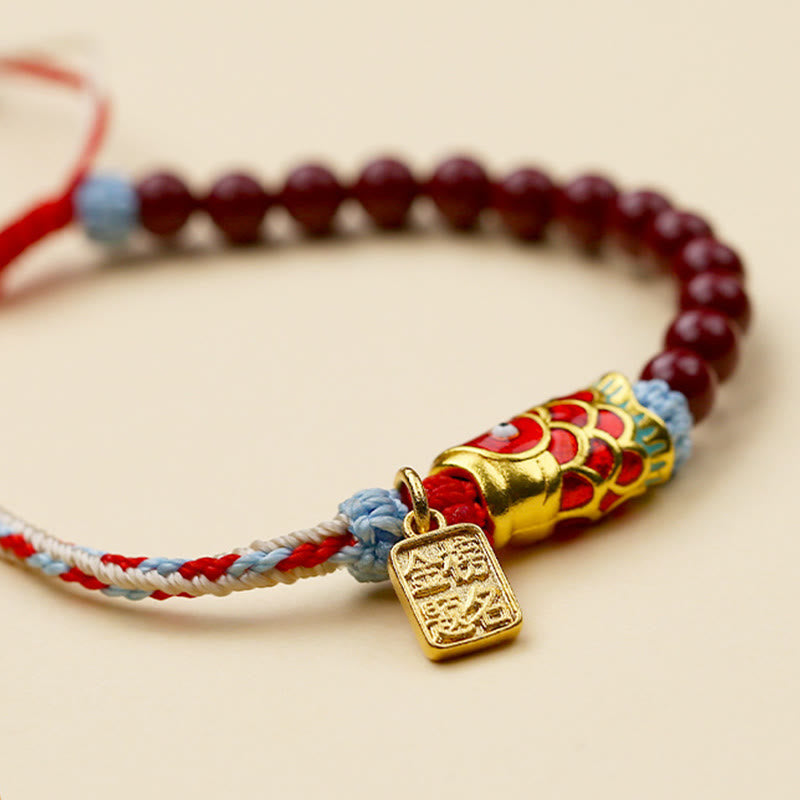 Cinnabar Koi Fish Blessing Bracelet – macro S-curve layout, gold koi charm, enamel scales, cinnabar beads, cream background