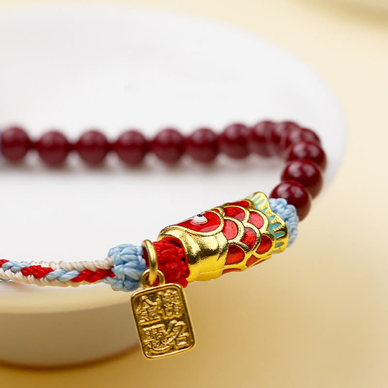 Cinnabar Koi Fish Blessing Bracelet – extreme macro 45-degree, gold koi fish charm detail, red beads, woven cord, cream bg