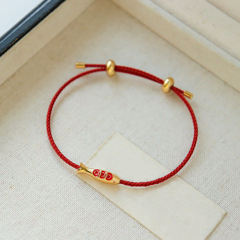 Brass Koi Fish Red String Bracelet – on cream linen near jewelry box, gold fish pendant, braided red lucky cord bracelet