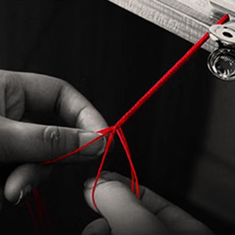 999 Gold Koi Fish Red String Bracelet – hands tying red cord knot, selective color, crafting process