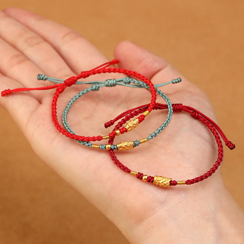 999 Gold Koi Fish Red String Bracelet – red and teal variants on palm, gold koi charms, lifestyle flat lay