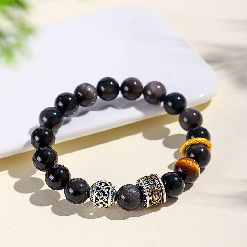 Silver Sheen Obsidian Tiger Eye Bracelet – diagonal angle with smartphone prop, showing obsidian bead polish and braided gold ring accent, natural stone bracelet