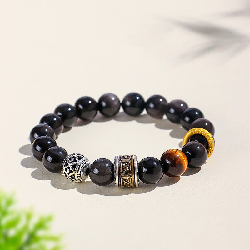 Silver Sheen Obsidian Tiger Eye Bracelet – black obsidian beads with tiger eye accent and engraved metal spacers on cream surface, men's protection bracelet
