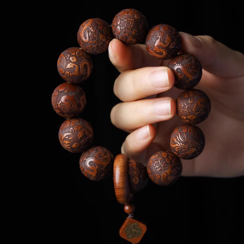 Rosewood Dragon Phoenix Gourd Bracelet – held in hand dragon carvings black backdrop, Power