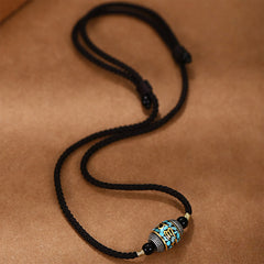 Dzi Bead Om Mani Padme Hum Rotatable Pendant – Top-down view of gold Tibetan script on turquoise mosaic bead, spiritual necklace