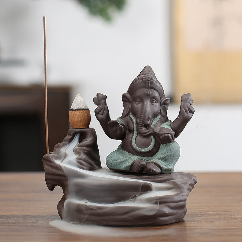 Ganesh Backflow Incense Burner - Brown ceramic Ganesha with sage green dhoti, active smoke waterfall, purple clay