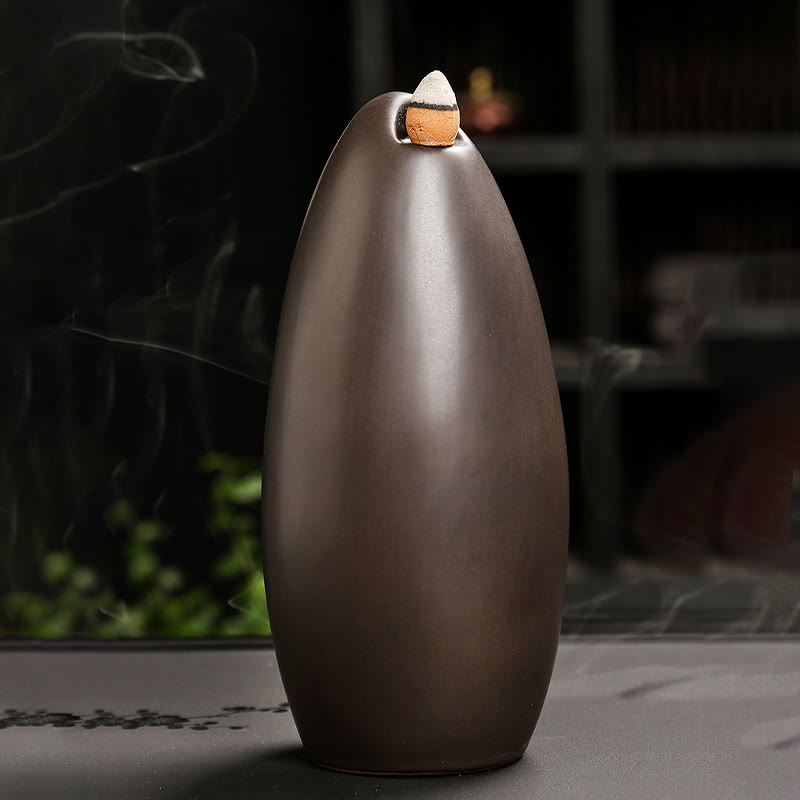 Mountain Water Buddha Hand Incense Burner – Matte bronze teardrop with lit cone, zen decor