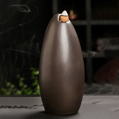 Mountain Water Buddha Hand Incense Burner – Matte bronze teardrop with lit cone, zen decor