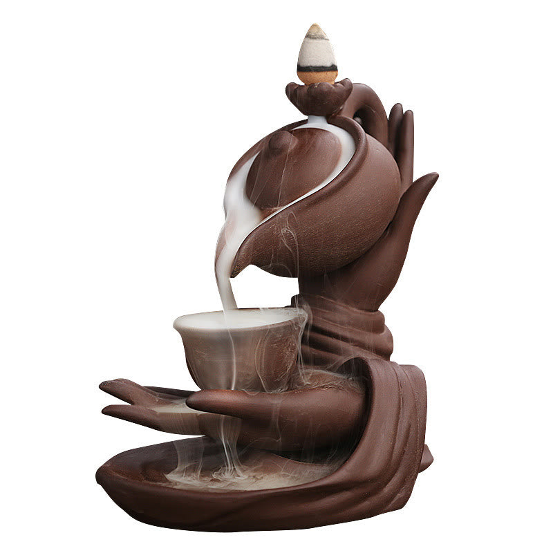 Buddha Hand Teapot Incense Burner – White background, teapot pours smoke into cup, two hands, zen