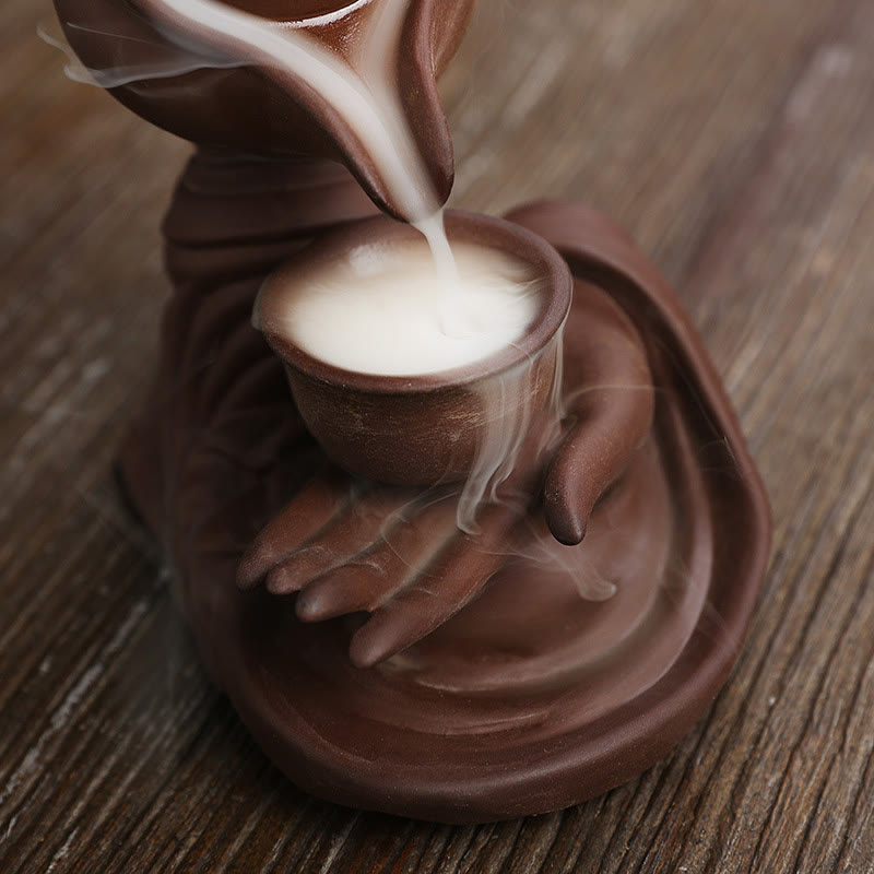 Buddha Hand Teapot Incense Burner – Teapot pours smoke into cup on palm, circular base, wood table