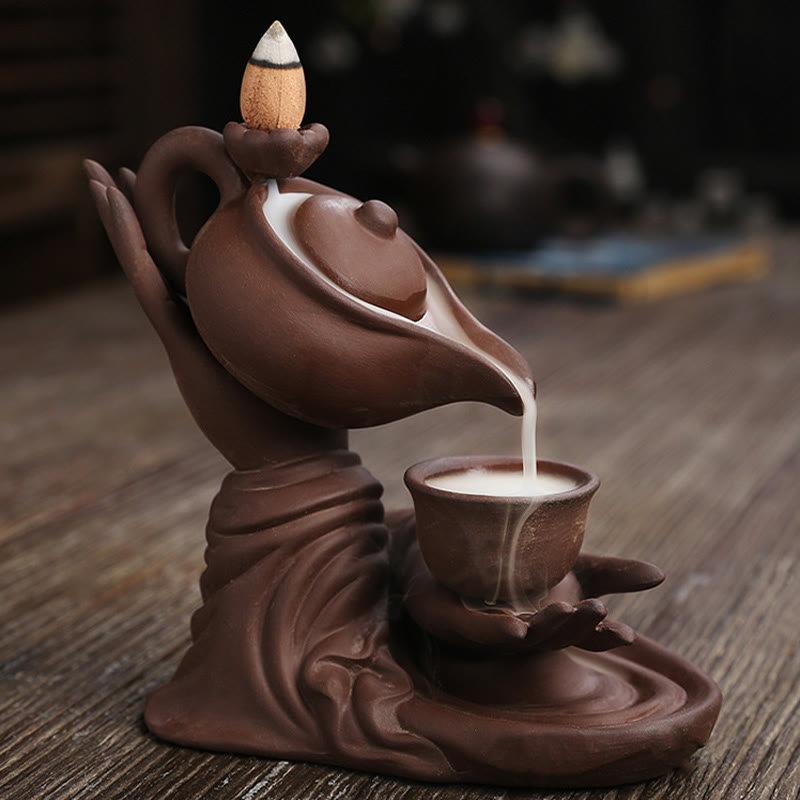 Buddha Hand Teapot Incense Burner – Warm brown teapot pouring smoke to cup, fabric-draped base