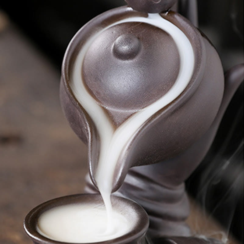 Buddha Hand Teapot Incense Burner – Dark teapot pours into small cup, close-up of liquid smoke flow
