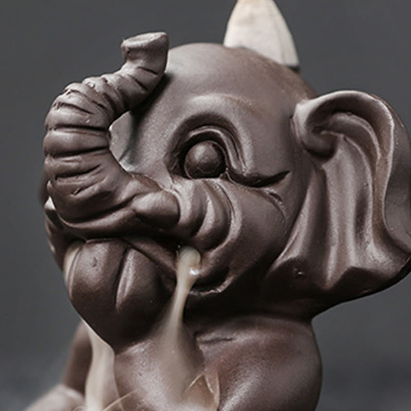 Cute Elephant Incense Burner – Rear view with cone in back, wisp of smoke, dark surface