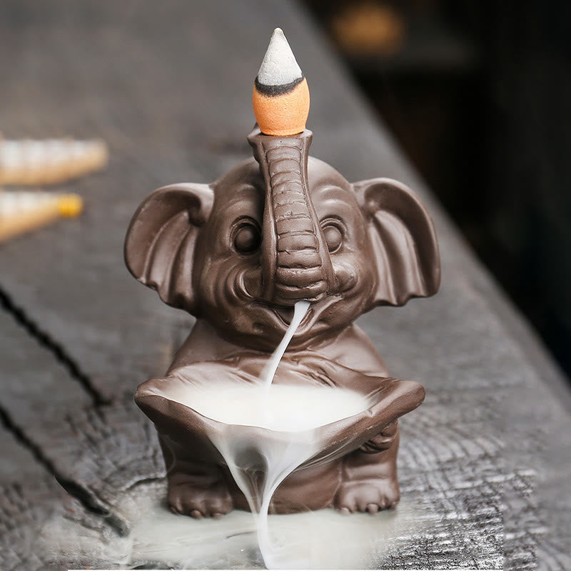 Elephant Backflow Incense Burner - Smoke waterfall flowing from trunk into bowl on dark wood, purple clay censer