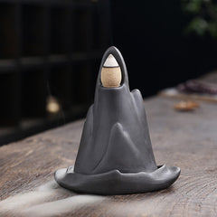 Little Monk Purple Clay Backflow Incense Burner - Single gray peak with cascading smoke on wood, zen incense cone