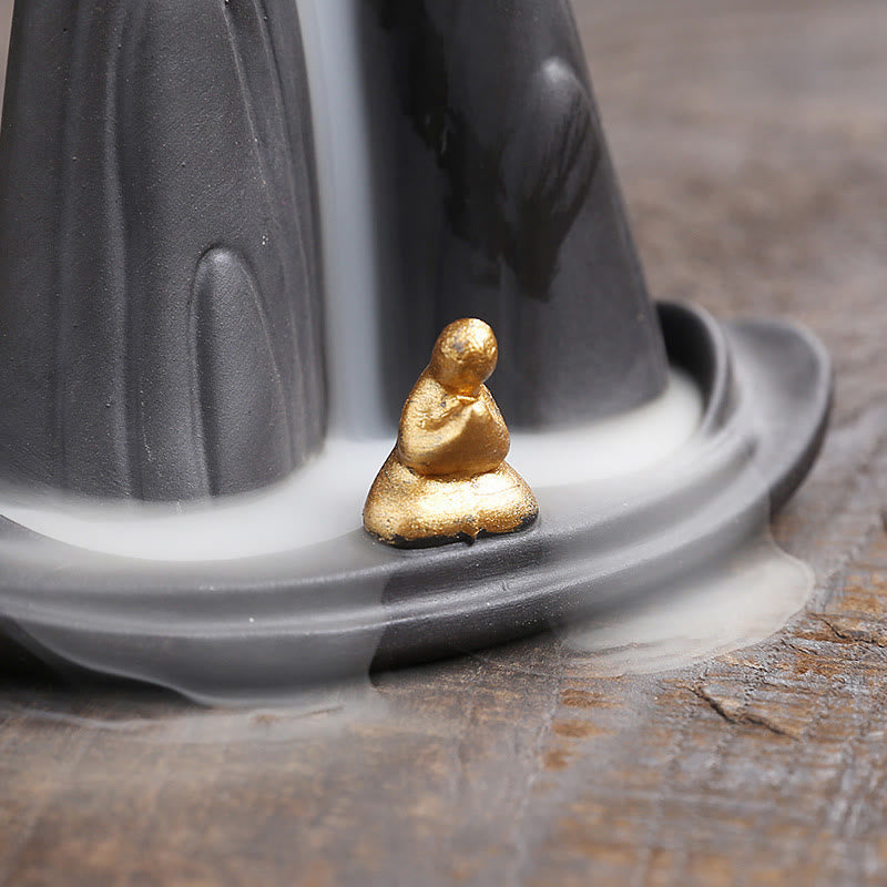 Little Monk Purple Clay Backflow Incense Burner - Gold meditating monk on dark mountain with smoke, zen healing