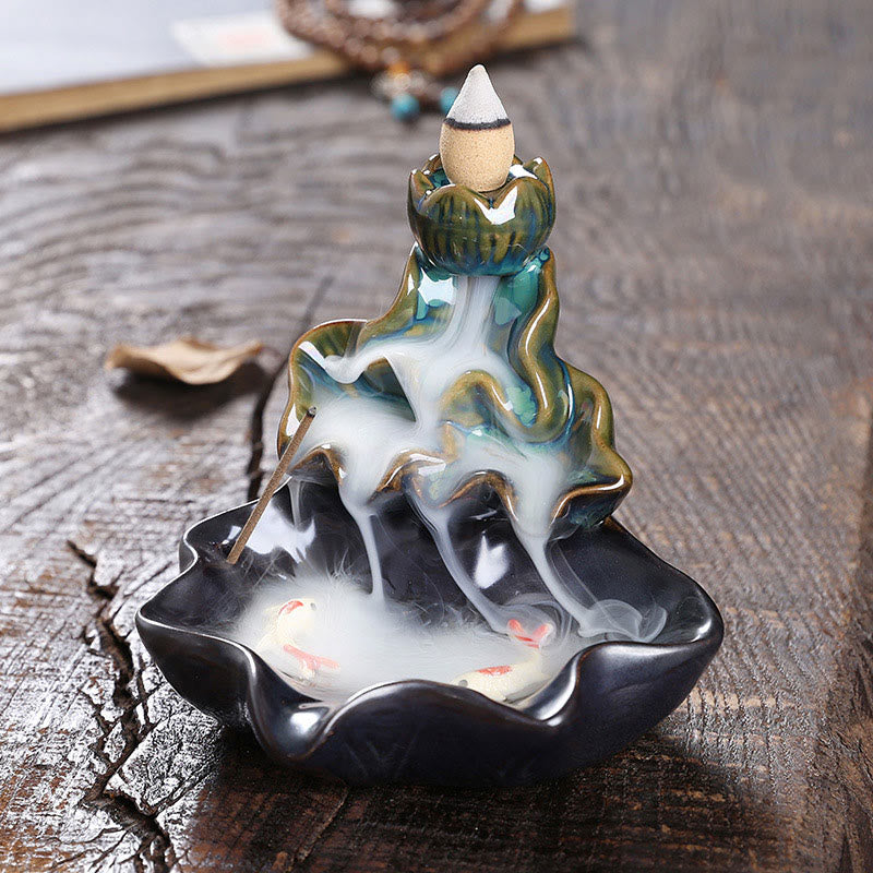 Lotus Leaf Koi Fish Incense Burner – teal tiered lotus with smoke cascade on dark wood, backflow decoration