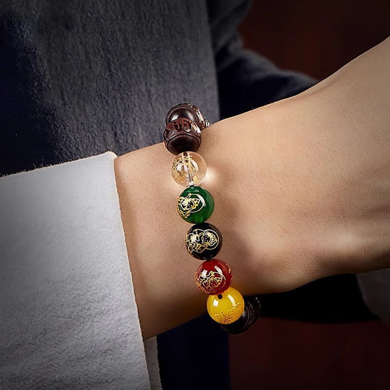Five Directions Wealth Bracelet - Wrist shot revealing zodiac gold engravings on five-color beads, carved sandalwood