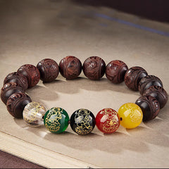 Five Directions Wealth Bracelet - Carved sandalwood beads with five-element gemstone accents on parchment, spiritual jewelry