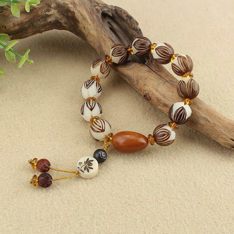 Tibetan Mala Bodhi Seed Lotus Bracelet - on driftwood with greenery, natural props, organic